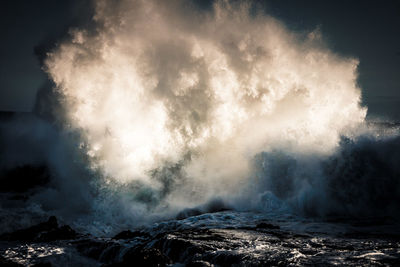 Waves splashing in sea against sky