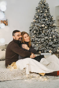 Happy couple celebrating romantic christmas eve at home. christmas interior decoration for family