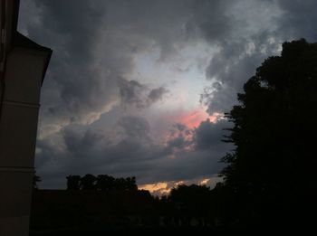 Silhouette of trees against cloudy sky