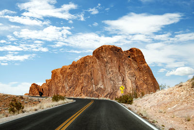 Road by rock formation against sky