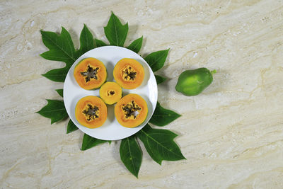 High angle view of fruits and leaves on table