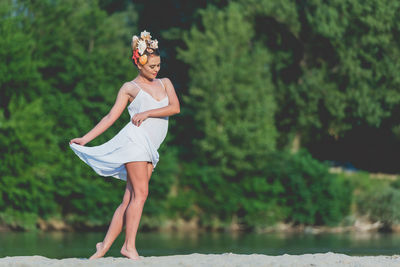 Full length of woman standing against trees