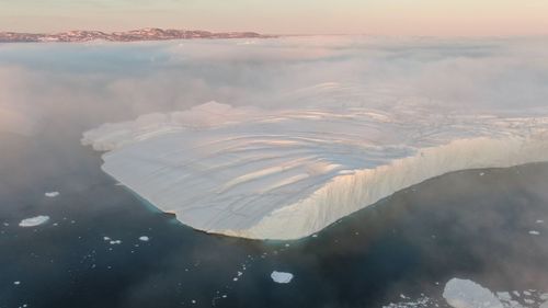 Aerial view of sea against sky during sunset