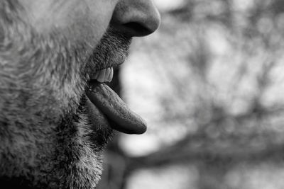 Midsection of man sticking out tongue