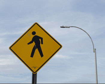 Low angle view of road sign against sky