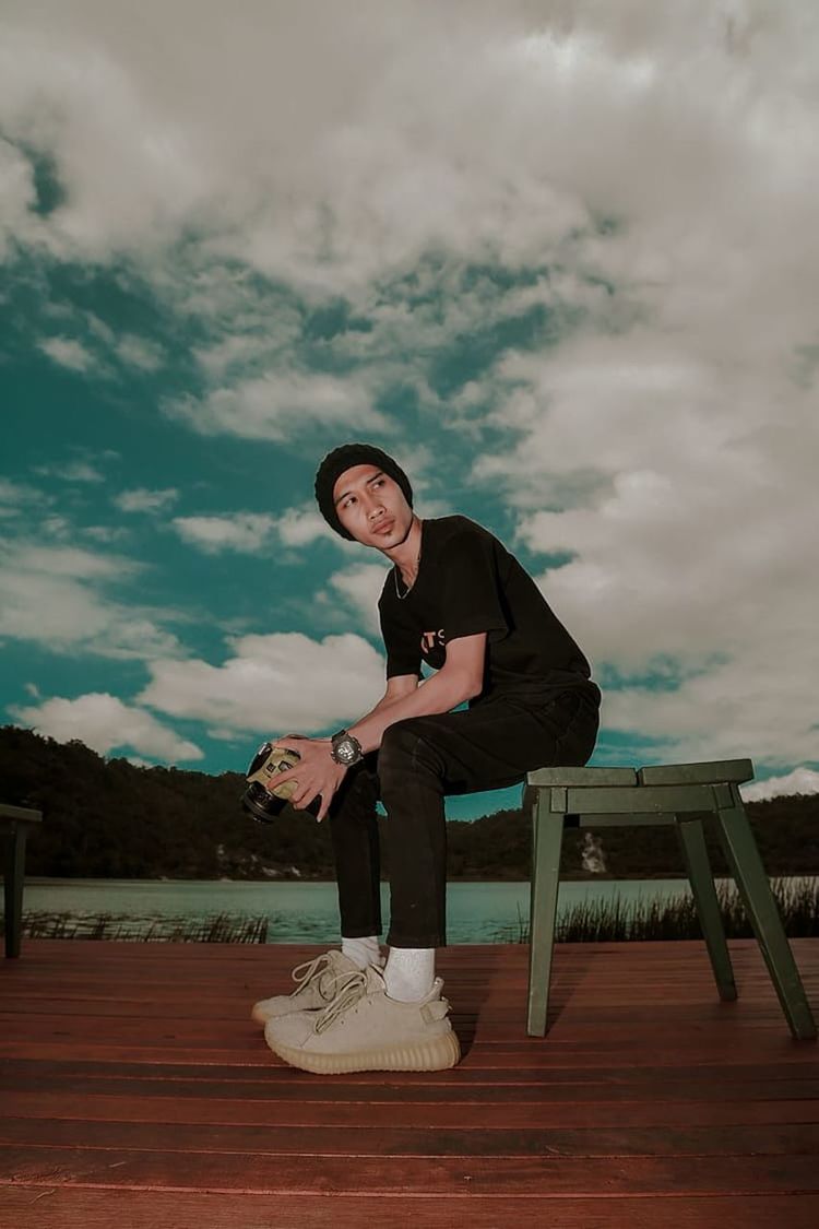 one person, full length, cloud, sky, adult, sitting, seat, young adult, blue, footwear, nature, furniture, person, lifestyles, clothing, men, leisure activity, standing, casual clothing, white, bench