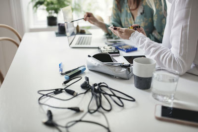 Midsection of woman using laptop on table