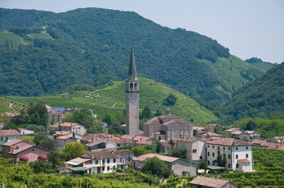 Houses amidst trees and buildings against mountains