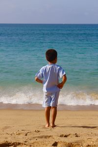 Rear view of boy standing on beach