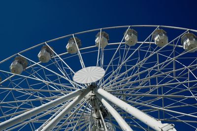 Low angle view of ferris wheel against blue sky