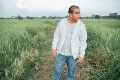 Portrait of young man standing on field