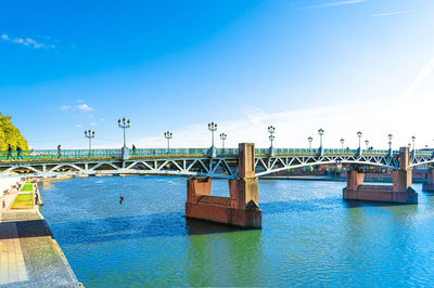 Bridge over sea against blue sky