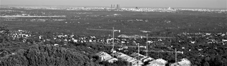 High angle view of field by buildings against sky