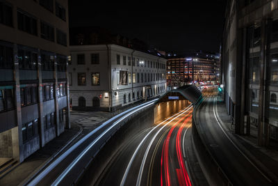 High angle view of light trails on street amidst buildings at night