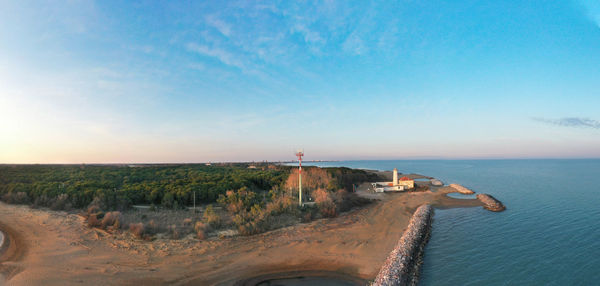 Bibione lighthouse from above at sunset in a panoramic aerial view	with sea and blue sky