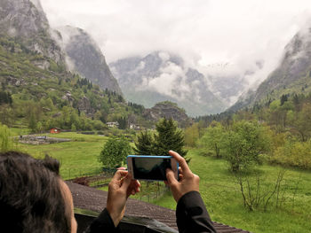 Woman photographing through mountain landscape