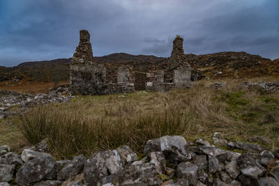 Old ruin building on field against sky