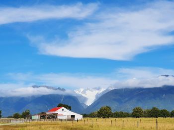 Scenic view of houses and mountains against sky