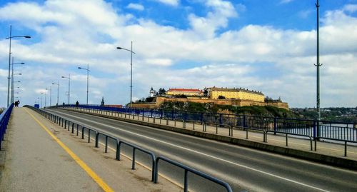 Train on road in city against sky