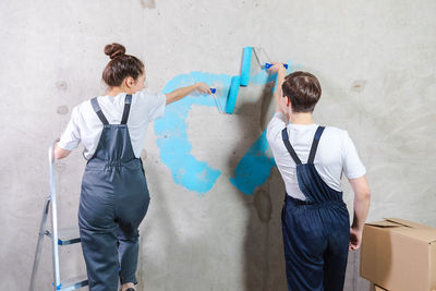 Rear view of couple standing against wall