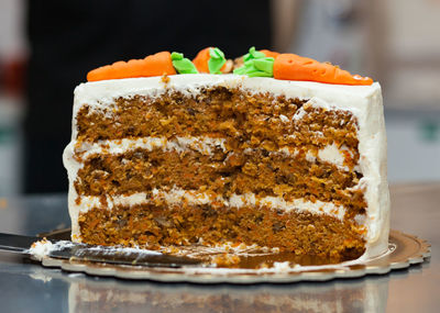 Carrot cake with cream cheese frosting and little carrots on top