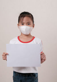 Portrait of boy standing against white background