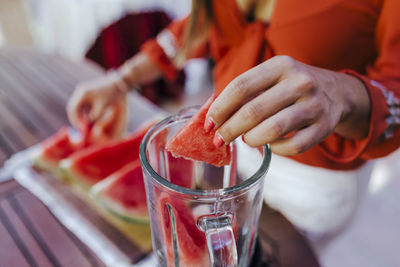 Midsection of woman holding ice cream in glass