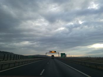 Road in city against storm clouds