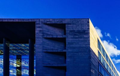 Low angle view of modern building against blue sky