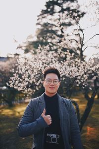 Portrait of young man standing against plants