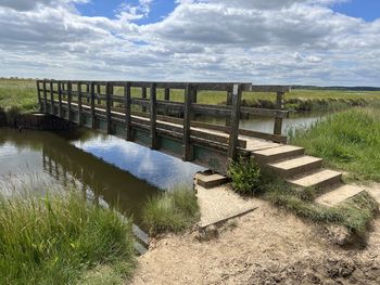 Beautiful summer landscape sky reflection in water by beach bridge walberswick suffolk uk coast 