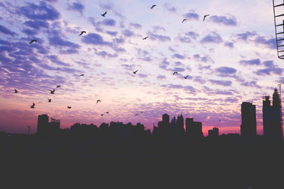 Silhouette buildings against sky during sunset
