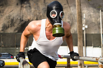 Man wearing gas mask exercising outdoors