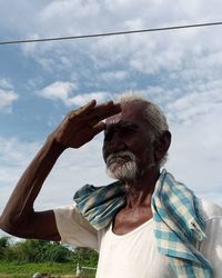 Portrait of man drinking against cloudy sky