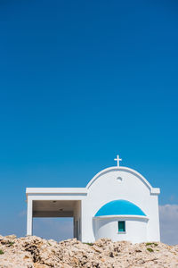 Traditional greek white chapel with a blue roof on the seaside. agioi anargyroi chapel, cyprus