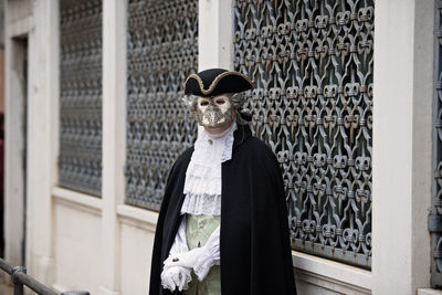 Portrait of man in costume standing against building