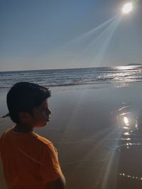 Boy on beach against sky