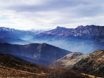 Scenic view of snowcapped mountains against cloudy sky