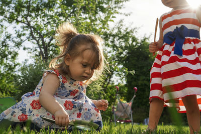 Children playing in the garden with magnifier.