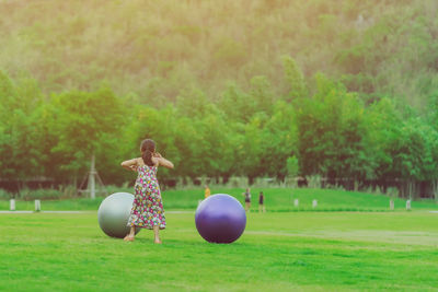 Woman with umbrella on field in park