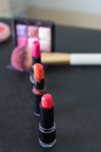 High angle view of make-up brush and lipsticks on table