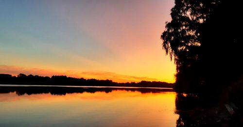 Scenic view of lake against orange sky