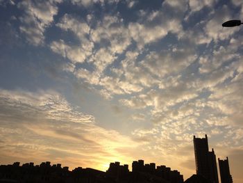 Low angle view of buildings against cloudy sky