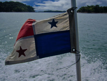 Close-up of flag against blue sea