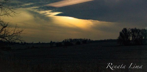 Scenic view of field against sky at sunset
