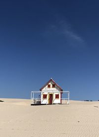 House on beach against clear blue sky