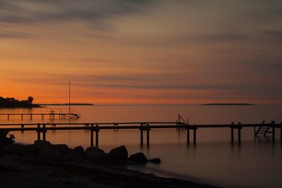 Scenic view of pier over sea against sky during sunset