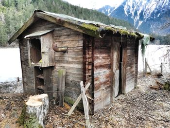 Old wooden house on field by building