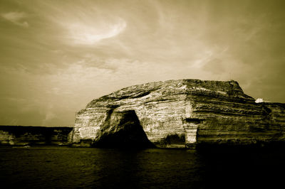 Ancient structure against cloudy sky