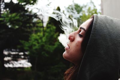 Close-up of young woman against tree